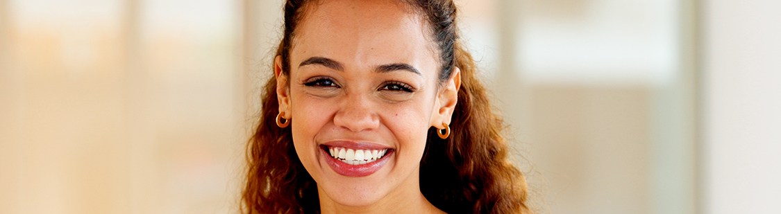 Woman in orange shirt standing and smiling