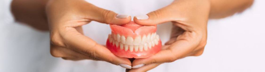 Lady presents viewer with dentures